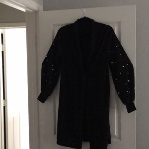 Black sweater with pearl sleeves.